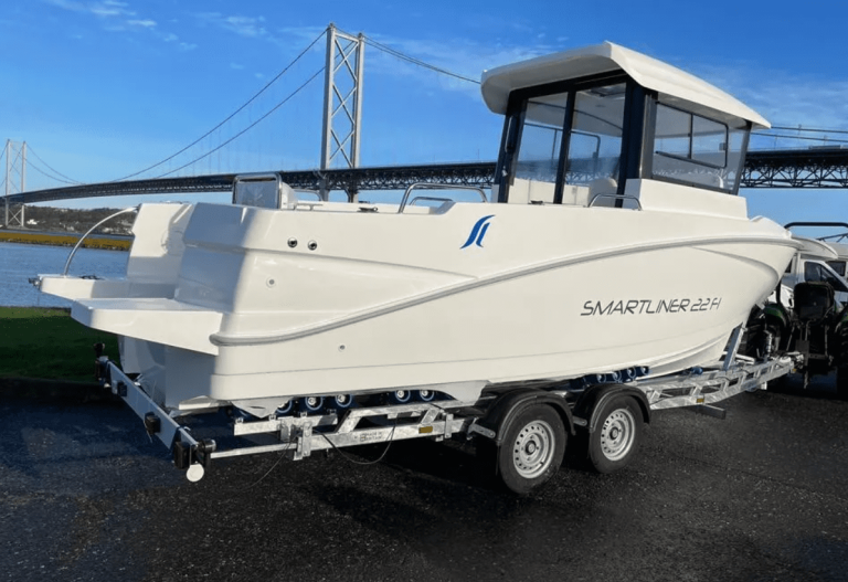 White boat on trailer by bridge